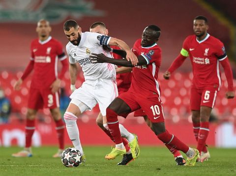 LIVERPOOL, ENGLAND - APRIL 14: Karim Benzema of Real Madrid is challenged by Sadio Mane of Liverpool during the UEFA Champions League Quarter Final Second Leg match between Liverpool FC and Real Madrid at Anfield on April 14, 2021 in Liverpool, England. Sporting stadiums around the UK remain under strict restrictions due to the Coronavirus Pandemic as Government social distancing laws prohibit fans inside venues resulting in games being played behind closed doors. (Photo by Shaun Botterill/Getty Images)