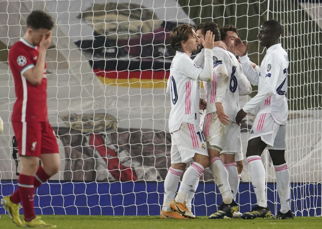 Liverpool's Diogo Jota, left, reacts as Real Madrid players celebrate at the end of the Champions League quarter final second leg soccer match between Liverpool and Real Madrid at Anfield stadium in Liverpool, England, Wednesday, April 14, 2021. (AP Photo/Jon Super)
