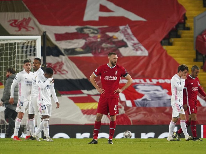 Liverpools Nathaniel Phillips, center, reacts at the end of the Champions League quarter final second leg soccer match between Liverpool and Real Madrid at Anfield stadium in Liverpool, England, Wednesday, April 14, 2021. (AP Photo/Jon Super)