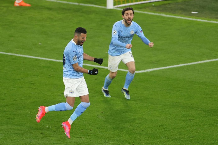 Riyad Mahrez DORTMUND, GERMANY - APRIL 14: Riyad Mahrez of Manchester City celebrates with team mate Bernardo Silva (R) after scoring their side's first goal from the penalty spot during the UEFA Champions League Quarter Final Second Leg match between Borussia Dortmund and Manchester City at Signal Iduna Park on April 14, 2021 in Dortmund, Germany. Sporting stadiums around Germany remain under strict restrictions due to the Coronavirus Pandemic as Government social distancing laws prohibit fans inside venues resulting in games being played behind closed doors. (Photo by Friedemann Vogel - Pool/Getty Images)
