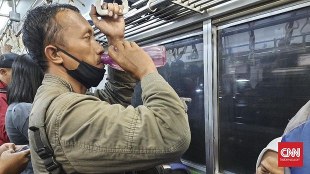 Seorang karyawan toko onderdil mobil asal Bogor berbuka puasa di Commuter Line pada Kamis (15/4).