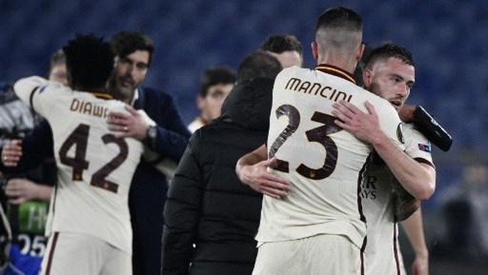 Romas French midfielder Jordan Veretout (R) and Romas Italian defender Gianluca Mancini embrace at the end of the UEFA Europa League quarter final second leg football match AS Rome vs Ajax Amsterdam on April 15, 2021 at the Olympic stadium in Rome. (Photo by Filippo MONTEFORTE / AFP)