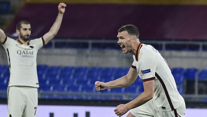 Romas Edin Dzeko, right, celebrates after scoring his teams first goal during the Europa League second leg quarterfinal soccer match between Roma and Ajax at Romes Olympic stadium, Italy, Thursday, April 15, 2021. (Luciano Rossi/LaPresse via AP)
