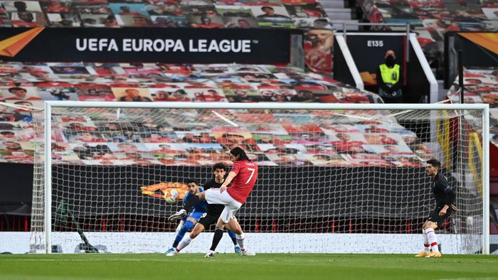 MANCHESTER, ENGLAND - APRIL 15: Edinson Cavani of Manchester United shoots to score the opening goal watched by a lone steward in the stand during the UEFA Europa League Quarter Final Second Leg match between Manchester United and Granada CF at Old Trafford on April 15, 2021 in Manchester, England. Sporting stadiums around Europe remain under strict restrictions due to the Coronavirus Pandemic as Government social distancing laws prohibit fans inside venues resulting in games being played behind closed doors. (Photo by Stu Forster/Getty Images)