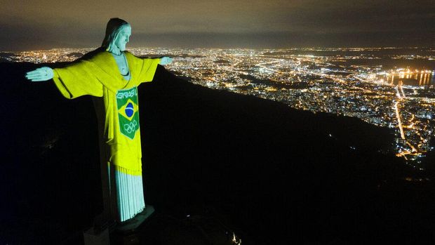 The colors of the Brazilian Olympic team are projected on the statue of Christ the Redeemer by the Brazilian Olympic Committee as a reminder of how sport can inspire in the fight against COVID-19, one hundred days before the Tokyo Olympic Games, in Rio de Janeiro, Brazil, Wednesday, April 14, 2021. (AP Photo/Lucas Dumphreys)