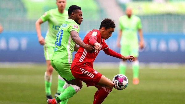 WOLFSBURG, GERMANY - APRIL 17: Jamal Musiala of FC Bayern Muenchen is challenged by Ridle Baku of VfL Wolfsburg during the Bundesliga match between VfL Wolfsburg and FC Bayern Muenchen at Volkswagen Arena on April 17, 2021 in Wolfsburg, Germany. Sporting stadiums around Germany remain under strict restrictions due to the Coronavirus Pandemic as Government social distancing laws prohibit fans inside venues resulting in games being played behind closed doors. (Photo by Martin Rose/Getty Images)