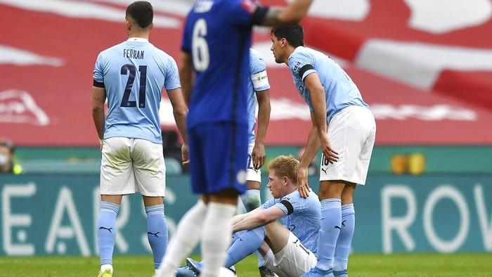 Manchester Citys Kevin De Bruyne sits on the field after injuring during the English FA Cup semifinal soccer match between Chelsea and Manchester City at Wembley Stadium in London, England, Saturday, April 17, 2021. (Ben Stansall, Pool via AP)