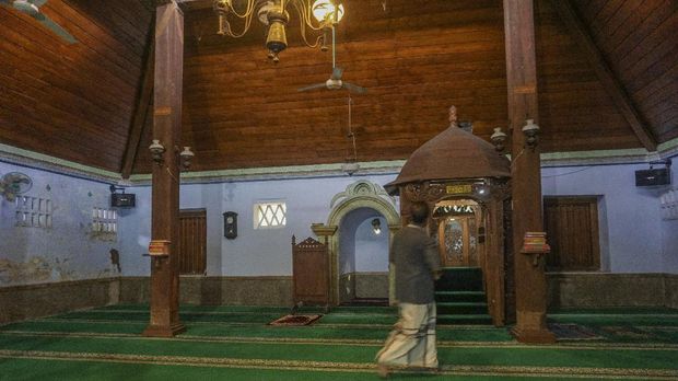 Pengurus masjid menunjukan pilar kayu penyangga masjid di Masjid Sapuro, Pekalongan, Jawa Tengah, Sabtu (17/4/2021). Menurut pengurus masjid, Masjid Jami Aulia atau Masjid Sapuro dibangun sekitar abad ke-16 oleh empat orang utusan Demak yaitu Kiai Maksum, Kiai Sulaiman, Kiai Lukman, dan Kiai Kudung dengan kayu-kayu bangunan masjid yang merupakan sisa pembangunan Masjid Agung Demak yang dibangun pada tahun 1479 Masehi. ANTARA FOTO/Harviyan Perdana Putra