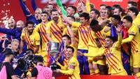 Lionel Messi (duduk bawah memegang piala), terlihat begitu tersenyum dan bahagia. Tak ayal, Barcelona sempat naik-turun performanya dan sudah tersisih di Liga Champions (Getty Images/Fran Santiago)