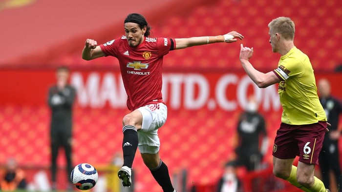 MANCHESTER, ENGLAND - APRIL 18: Edinson Cavani of Manchester United is challenged by Ben Mee of Burnley during the Premier League match between Manchester United and Burnley at Old Trafford on April 18, 2021 in Manchester, England. Sporting stadiums around the UK remain under strict restrictions due to the Coronavirus Pandemic as Government social distancing laws prohibit fans inside venues resulting in games being played behind closed doors. (Photo by Gareth Copley/Getty Images)