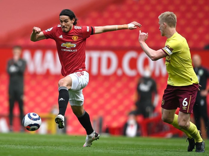 MANCHESTER, ENGLAND - APRIL 18: Edinson Cavani of Manchester United is challenged by Ben Mee of Burnley during the Premier League match between Manchester United and Burnley at Old Trafford on April 18, 2021 in Manchester, England. Sporting stadiums around the UK remain under strict restrictions due to the Coronavirus Pandemic as Government social distancing laws prohibit fans inside venues resulting in games being played behind closed doors. (Photo by Gareth Copley/Getty Images)