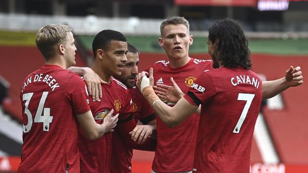 Manchester United's Mason Greenwood, centre, is congratulated by teammates after scoring during the English Premier League soccer match between Manchester United and Burnley at the Old Trafford stadium in Manchester, England, Sunday, April 18, 2021. (Gareth Copley/Pool via AP)