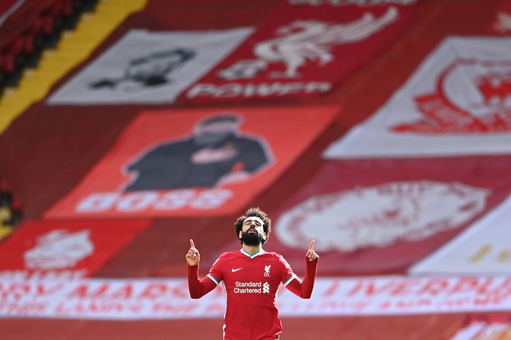 LIVERPOOL, ENGLAND - APRIL 10: Mohamed Salah of Liverpool celebrates after scoring their team's first goal during the Premier League match between Liverpool and Aston Villa at Anfield on April 10, 2021 in Liverpool, England. Sporting stadiums around the UK remain under strict restrictions due to the Coronavirus Pandemic as Government social distancing laws prohibit fans inside venues resulting in games being played behind closed doors.  (Photo by Laurence Griffiths/Getty Images)