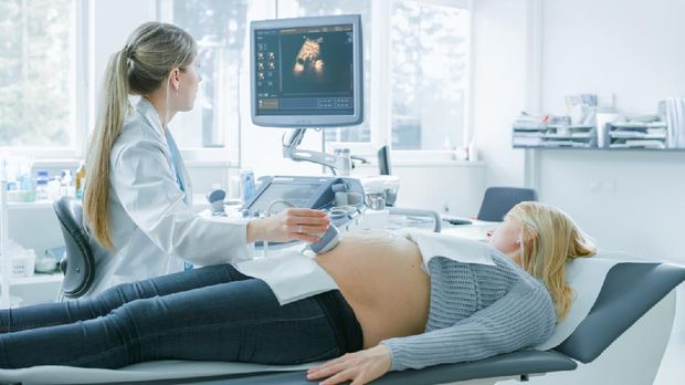 In the Hospital, Pregnant Woman Getting Ultrasound Screening, Obstetrician Checks Picture of the Healthy Baby on the Computer Screen. Happy Future Mother Waiting for her Baby to Born.