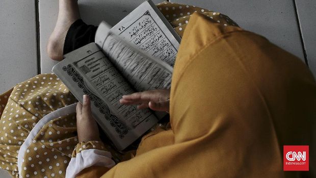 Anak-anak di salah satu sekolah TK di gang Mushola, Jakarta Selatan, melakukan tadarus Alquran dengan menggunakan pelindung wajah dan masker di Bulan suci Ramadhan, saat pandemi Covid-19. Selasa (20/4/2021). Bulan suci Ramadhan dimanfaatkan umat muslim untuk memperbanyak amalan dan ibadah di antaranya sholat sunah, zikir, dan tadarus Alquran. CNN Indonesia/Andry Novelino