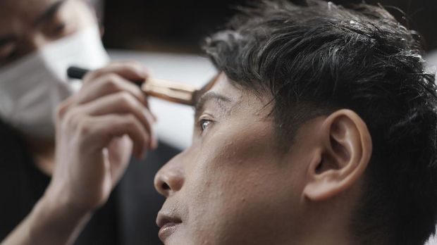 Yoshihiro Kamichi, a 44-year-old office worker, receives makeup and gets his hair done by a makeup artist at Ikemen-Works, a makeup salon for men, in Tokyo Wednesday, Feb. 3, 2021. The coronavirus pandemic has been pushing businesses to the edge in Japan, but some in the men's beauty industry have seen an unexpected expansion in their customer base. Japanese businessmen in their 40s, 50s and 60s who had little interest in cosmetics before the pandemic are now buying makeup. (AP Photo/Eugene Hoshiko)