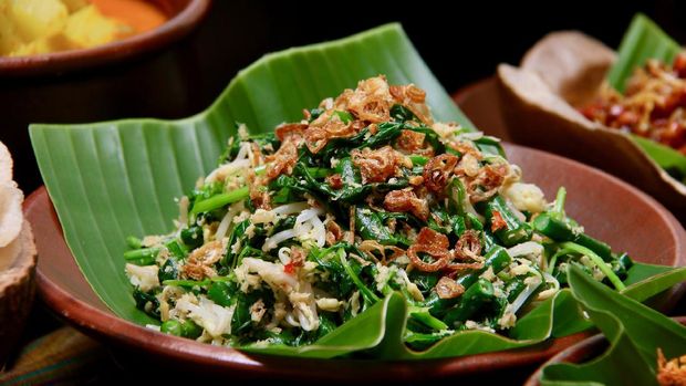 Jukut Urap, the popular Balinese vegetable salad accompanying many Balinese meals, especially Nasi Campur Bali. Cooked spinach, long beans and bean sprouts mixed with spicy grated coconut. Served on an earthenware plate lined with banana leaf.