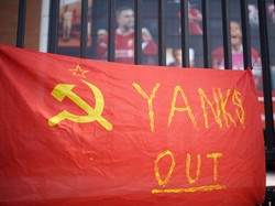 Fans Liverpool mengibarkan simbol Kelas Pekerja, bendera palu arit, dengan tuntutan mengusir Yanks (orang-orang Amerika). The Reds memang dimiliki Fenway Sports Grup dari AS. (Foto: Getty Images/Christopher Furlong)