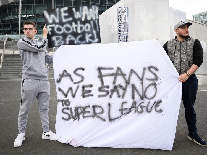 LONDON, UNITED KINGDOM - APRIL 20: Manchester United fan Jack Newson (L) and Tottenham Hotspur fan Cameron Bull hold their handmade signs as they protest against the proposed Super League outside the Tottenham Hotspur stadium on April 20, 2021 in London, United Kingdom. Six English premier league teams have announced they are part of plans for a breakaway European Super League. Arsenal, Manchester United, Manchester City, Liverpool, Chelsea and Tottenham Hotspur will join 12 other European teams in a closed league similar to that of the NFL American Football League. In a statement released last night, the new competition 