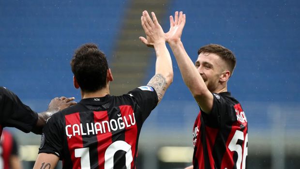 MILAN, ITALY - APRIL 21: Hakan Calhanoglu of A.C. Milan celebrates after scoring their sides first goal with team mate Alexis Saelemaekers during the Serie A match between AC Milan  and US Sassuolo at Stadio Giuseppe Meazza on April 21, 2021 in Milan, Italy.Sporting stadiums around Italy remain under strict restrictions due to the Coronavirus Pandemic as Government social distancing laws prohibit fans inside venues resulting in games being played behind closed doors. (Photo by Marco Luzzani/Getty Images)