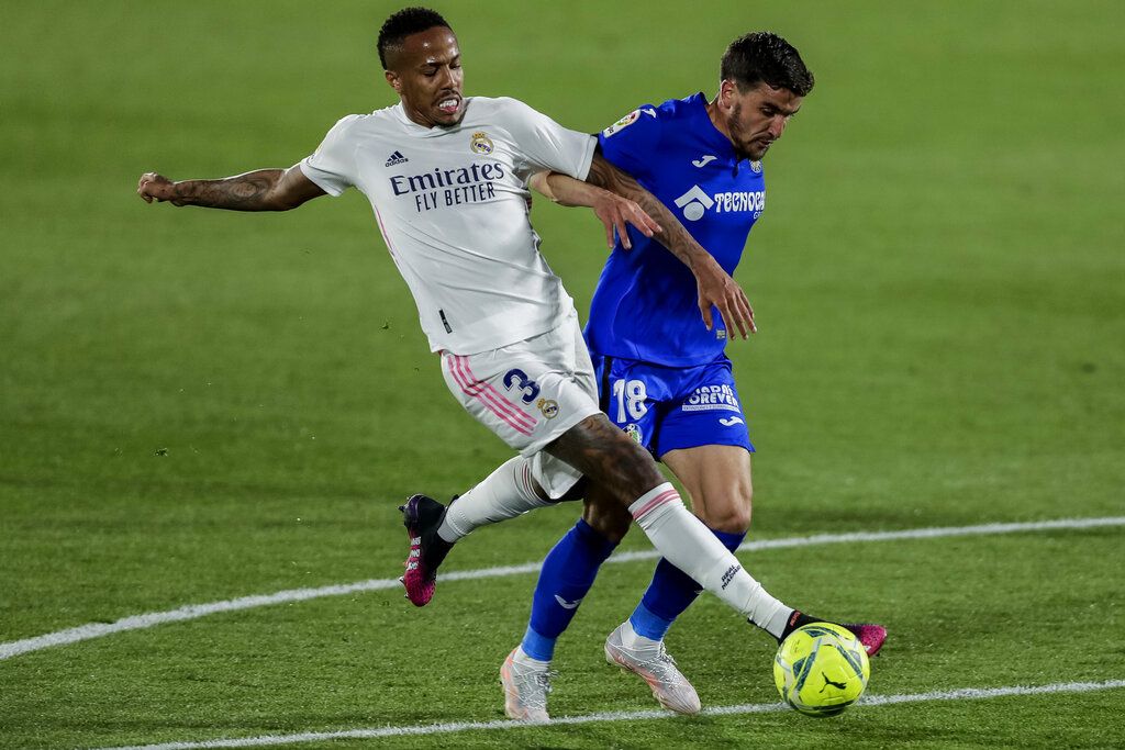 Real Madrid's Eder Militao, left, duels for the ball with Getafe's Mauro Arambarri during the Spanish La Liga soccer match between Getafe and Real Madrid at the Alfonso Perez stadium in Getafe, Spain, Sunday, April 18, 2021. (AP Photo/Manu Fernandez)