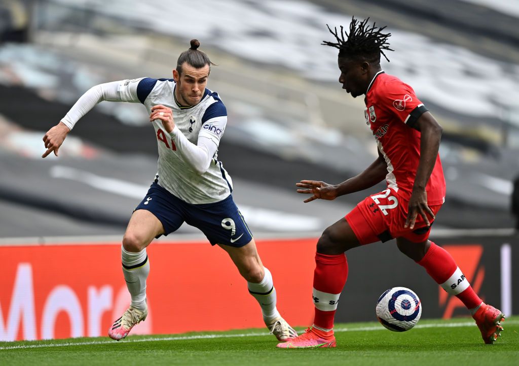 LONDON, ENGLAND - APRIL 21: Gareth Bale of Tottenham Hotspur runs with the ball whilst under pressure from Mohammed Salisu of Southampton during the Premier League match between Tottenham Hotspur and Southampton at Tottenham Hotspur Stadium on April 21, 2021 in London, England. Sporting stadiums around the UK remain under strict restrictions due to the Coronavirus Pandemic as Government social distancing laws prohibit fans inside venues resulting in games being played behind closed doors. (Photo by Justin Setterfield/Getty Images)