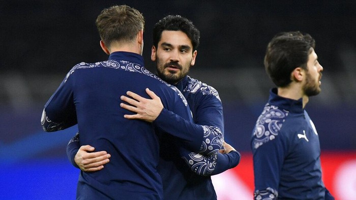 Manchester Citys Ilkay Gundogan hugs a teammate before the Champions League quarterfinal second leg soccer match between Borussia Dortmund and Manchester City at the Signal Iduna Park stadium in Dortmund, Germany, Wednesday, April 14, 2021. (AP Photo/Martin Meissner, Pool)