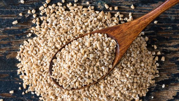 Uncooked Steel Cut Oats on a Wood Spoon