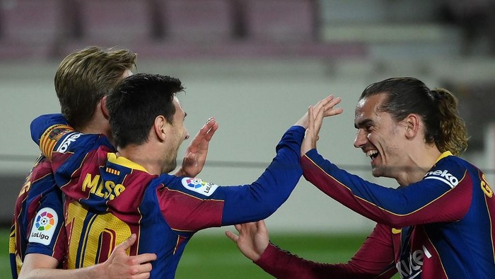 Barcelonas Argentinian forward Lionel Messi celebrates with Barcelonas Dutch midfielder Frenkie De Jong (L) and Barcelonas French midfielder Antoine Griezmann (R) after scoring his teams third goal during the Spanish League football match between Barcelona and Getafe at the Camp Nou stadium in Barcelona on April 22, 2021. (Photo by LLUIS GENE / AFP)