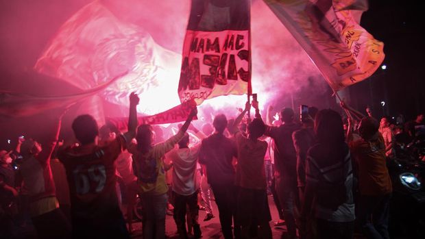 Suporter Persija menyalakan flare saat merayakan kemenangan Persija Jakarta pada laga final Piala Menpora 2021 di Bundaran Hotel Indonesia, Jakarta, Senin (26/4/2021). Suporter Persija The Jakmania berkonvoi memadati Bundaran HI merayakan kemenangan Persija Jakarta menjadi juara Piala Menpora 2021 usai mengalahkan Persib Bandung di Stadion Manahan Solo dengan agregrat 4-1. ANTARA FOTO/Ahmad Tri Hawaari/wpa/rwa.