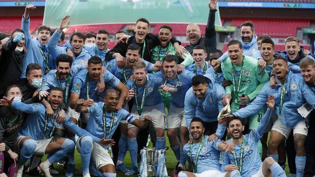 Manchester City players celebrate with the trophy at the end of the English League Cup final soccer match between Manchester City and Tottenham Hotspur at Wembley stadium in London, Sunday, April 25, 2021. Manchester City won 1-0. (AP Photo/Alastair Grant)