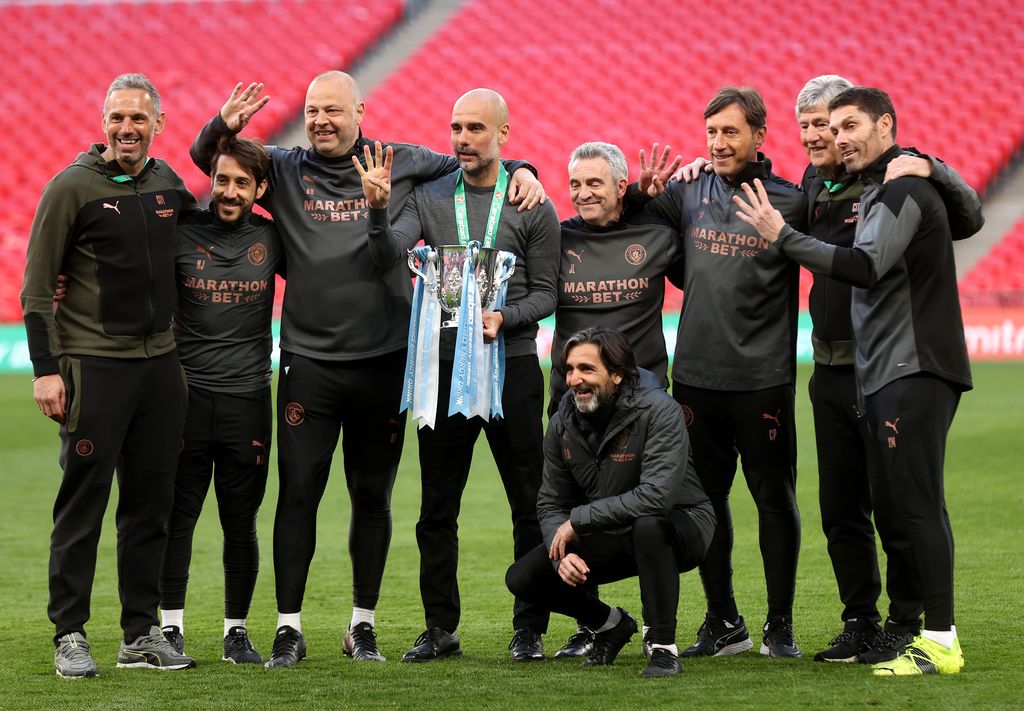 LONDON, ENGLAND - APRIL 25: Pep Guardiola, Manager of Manchester City and his backroom staff celebrates with the trophy after winning the Carabao Cup after the Carabao Cup Final between Manchester City and Tottenham Hotspur at Wembley Stadium on April 25, 2021 in London, England. 8,000 fans are due to watch the game at Wembley, the most at an outdoor sporting event in the UK since the coronavirus pandemic started in March, 2020. Each team has been given an allocation of 2,000 with the remaining tickets split between local residents and NHS staff. (Photo by Clive Rose/Getty Images)