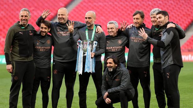 LONDON, ENGLAND - APRIL 25: Pep Guardiola, Manager of Manchester City and his backroom staff celebrates with the trophy after winning the Carabao Cup after the Carabao Cup Final between Manchester City and Tottenham Hotspur at Wembley Stadium on April 25, 2021 in London, England. 8,000 fans are due to watch the game at Wembley, the most at an outdoor sporting event in the UK since the coronavirus pandemic started in March, 2020. Each team has been given an allocation of 2,000 with the remaining tickets split between local residents and NHS staff. (Photo by Clive Rose/Getty Images)