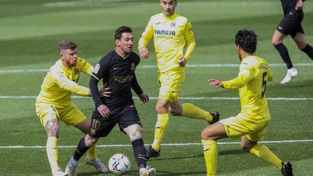 Barcelona's Lionel Messi, second left, vies for the ball surrounded of Villarreal players during the Spanish La Liga soccer match between Villarreal and FC Barcelona at the Ceramica stadium in Villarreal, Spain, Sunday, April 25, 2021. (AP Photo/Alberto Saiz)
