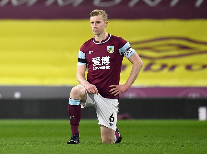 BURNLEY, ENGLAND - MARCH 03: Ben Mee of Burnley takes a knee in support of the Black Lives Matter movement prior to the Premier League match between Burnley and Leicester City at Turf Moor on March 03, 2021 in Burnley, England. Sporting stadiums around the UK remain under strict restrictions due to the Coronavirus Pandemic as Government social distancing laws prohibit fans inside venues resulting in games being played behind closed doors. (Photo by Peter Powell - Pool/Getty Images)