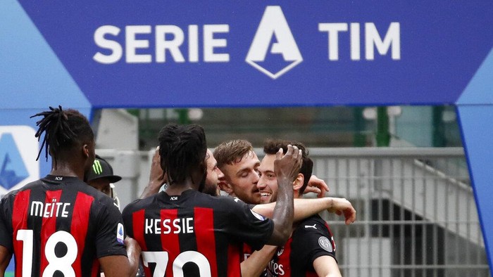 AC Milans Hakan Calhanoglu celebrates with teammates after scoring his sides opening goal during the Serie A soccer match between AC Milan and Sassuolo at the San Siro stadium, in Milan, Italy, Wednesday, April 21, 2021. (AP Photo/Antonio Calanni)