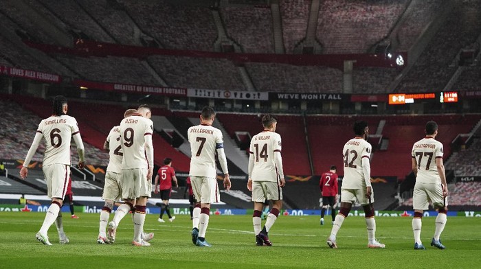 Romas Edin Dzeko with teammates after scoring his sides second goal during the Europa League semi final, first leg soccer match between Manchester United and Roma at Old Trafford in Manchester, England, Thursday, April 29, 2021. (AP Photo/Jon Super)