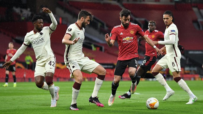 MANCHESTER, ENGLAND - APRIL 29: Bruno Fernandes of Manchester United battles for possession with Bryan Cristante of Roma during the UEFA Europa League Semi-final First Leg match between Manchester United and AS Roma at Old Trafford on April 29, 2021 in Manchester, England. Sporting stadiums around Europe remain under strict restrictions due to the Coronavirus Pandemic as Government social distancing laws prohibit fans inside venues resulting in games being played behind closed doors. (Photo by Michael Regan/Getty Images)