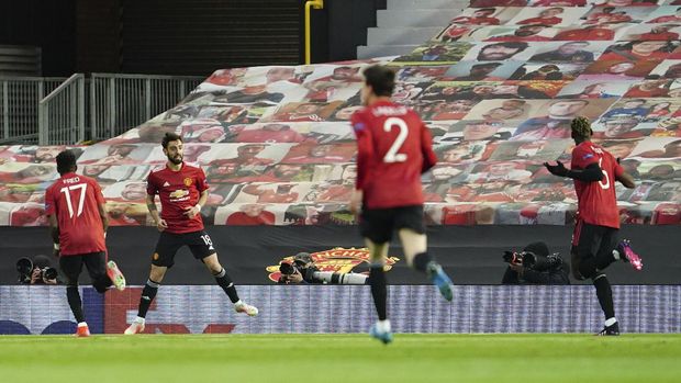 Manchester United's Bruno Fernandes, second left, celebrates with teammates after scoring his side's opening goal during the Europa League semi final, first leg soccer match between Manchester United and Roma at Old Trafford in Manchester, England, Thursday, April 29, 2021. (AP Photo/Jon Super)