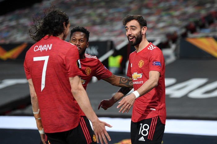 MANCHESTER, ENGLAND - APRIL 29: Bruno Fernandes of Manchester United celebrates with teammates Fred and Edinson Cavani after scoring their teams first goal during the UEFA Europa League Semi-final First Leg match between Manchester United and AS Roma at Old Trafford on April 29, 2021 in Manchester, England. Sporting stadiums around Europe remain under strict restrictions due to the Coronavirus Pandemic as Government social distancing laws prohibit fans inside venues resulting in games being played behind closed doors. (Photo by Michael Regan/Getty Images)