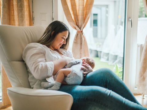 happy family mother playing and hug with newborn baby  in bed