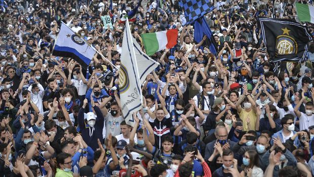 Inter Milan fans celebrate in Piazza Duomo square in front of the gothic cathedral after Inter Milan won its first Serie A title in more than a decade after second-placed Atalanta drew 1-1 at Sassuolo, in Milan, Italy, Sunday, May 2, 2021. Atalanta needed to win to avoid Inter mathematically clinching the title with four matches remaining. It was Inter's first trophy since 2011 and the first Serie A title since 2010. (Claudio Furlan/LaPresse via AP)