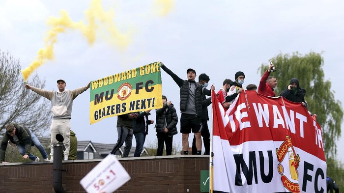 Fans holds up banners as they protest against the Glazer family, owners of Manchester United, before their Premier League match against Liverpool at Old Trafford, Manchester, England, Sunday, May 2, 2021. (Barrington Coombs/PA via AP)