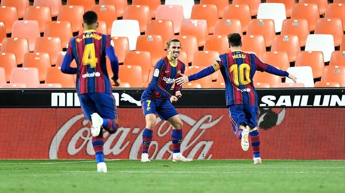 VALENCIA, SPAIN - MAY 02: Antoine Griezmann of FC Barcelona celebrates with team mate Lionel Messi after scoring their sides second goal during the La Liga Santander match between Valencia CF and FC Barcelona at Estadio Mestalla on May 02, 2021 in Valencia, Spain. Sporting stadiums around Spain remain under strict restrictions due to the Coronavirus Pandemic as Government social distancing laws prohibit fans inside venues resulting in games being played behind closed doors. (Photo by Aitor Alcalde/Getty Images)