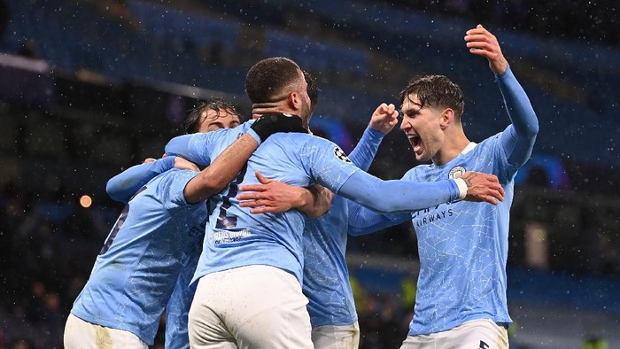 MANCHESTER, ENGLAND - MAY 04: Riyad Mahrez of Manchester City (obscure) celebrates with Kyle Walker and John Stones after scoring his teams second goal during the UEFA Champions League Semi Final Second Leg match between Manchester City and Paris Saint-Germain at Etihad Stadium on May 04, 2021 in Manchester, England. Sporting stadiums around the UK remain under strict restrictions due to the Coronavirus Pandemic as Government social distancing laws prohibit fans inside venues resulting in games being played behind closed doors. (Photo by Laurence Griffiths/Getty Images)
