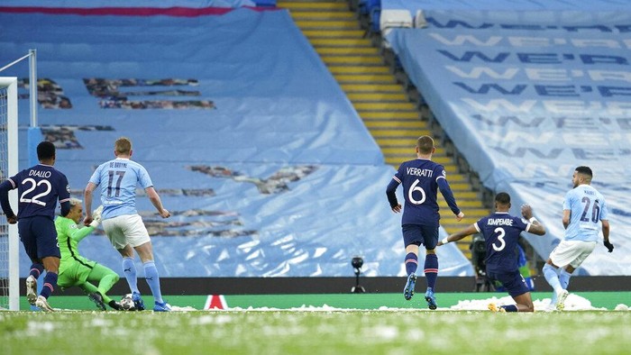 Manchester Citys Riyad Mahrez, right, scores his sides first goal during the Champions League semifinal second leg soccer match between Manchester City and Paris Saint Germain at the Etihad stadium, in Manchester, Tuesday, May 4, 2021. (AP Photo/Dave Thompson)