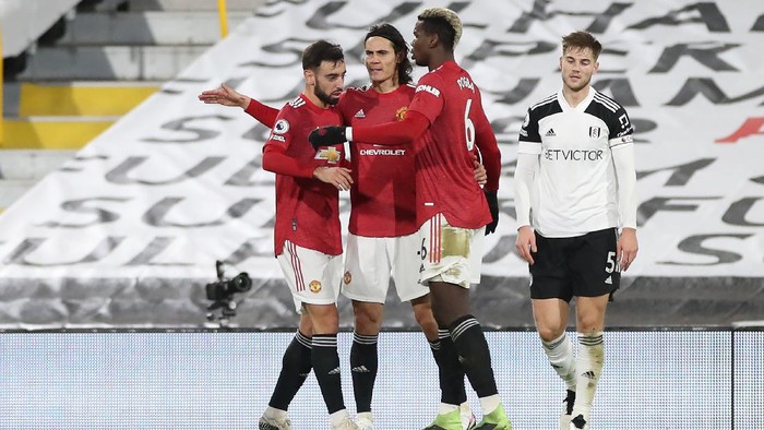 LONDON, ENGLAND - JANUARY 20: Edinson Cavani of Manchester United celebrates with team mates Bruno Fernandes and Paul Pogba after scoring their teams first goal during the Premier League match between Fulham and Manchester United at Craven Cottage on January 20, 2021 in London, England. Sporting stadiums around the UK remain under strict restrictions due to the Coronavirus Pandemic as Government social distancing laws prohibit fans inside venues resulting in games being played behind closed doors. (Photo by Peter Cziborra - Pool/Getty Images)