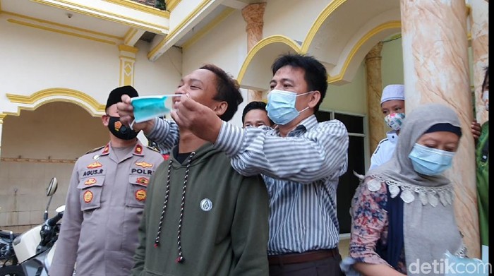 Kini, Roni memasangkan masker ke Nawir sebagai simbol keduanya telah berdamai.