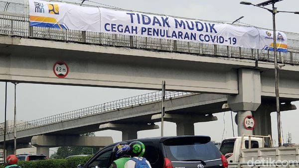 Spanduk Larangan Mudik Mejeng di JPO Gatot Subroto