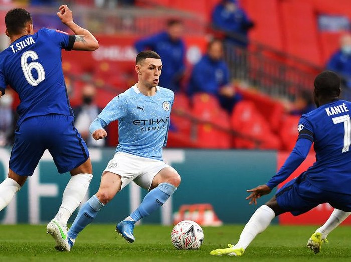 LONDON, ENGLAND - APRIL 17: Phil Foden of Manchester City takes on Thiago Silva of Chelsea and NGolo Kante of Chelsea during the Semi Final of the Emirates FA Cup match between Manchester City and Chelsea FC at Wembley Stadium on April 17, 2021 in London, England. Sporting stadiums around the UK remain under strict restrictions due to the Coronavirus Pandemic as Government social distancing laws prohibit fans inside venues resulting in games being played behind closed doors.  (Photo by Ben Stansall - Pool/Getty Images)